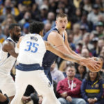 
              Denver Nuggets center Nikola Jokic, right, looks to pass the ball as Dallas Mavericks center Christian Wood, front,and forward Tim Hardaway Jr. defend during the first half of an NBA basketball game Tuesday, Dec. 6, 2022, in Denver. (AP Photo/David Zalubowski)
            