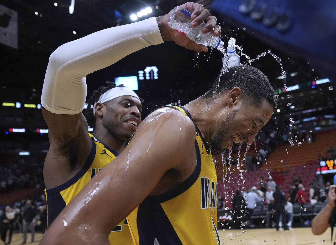 Indiana Pacers guard Buddy Hield, left, douses guard Tyrese Haliburton (0) after the team's NBA bas...