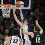 
              Gonzaga forward Drew Timme (2), second from right, shoots in front of Washington forward Jackson Grant (12) during the first half of an NCAA college basketball game, Friday, Dec. 9, 2022, in Spokane, Wash. (AP Photo/Young Kwak)
            