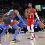 
              New Orleans Pelicans guard Devonte' Graham (4) goes against Oklahoma City Thunder forward Jalen Williams (8) during the second half of an NBA basketball game Friday, Dec. 23, 2022, in Oklahoma City. (AP Photo/Garett Fisbeck)
            