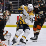 
              Nashville Predators center Juuso Parssinen, center, misses the puck on a rebound with Anaheim Ducks goaltender John Gibson, left, and right wing Troy Terry defending during the second period of an NHL hockey game in Anaheim, Calif., Friday, Dec. 30, 2022. (AP Photo/Alex Gallardo)
            