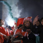 
              Moroccan fan light flares as they celebrate in Trafalgar Square in London Saturday, Dec. 10, 2022, after the World Cup quarterfinal match between Morocco and Portugal. Morocco won the game 1-0. (AP Photo/David Cliff )
            