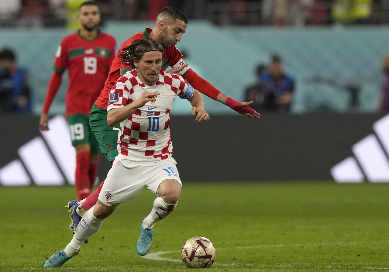 Croatia's Luka Modric, front, duels for the ball with Morocco's Hakim Ziyech during the World Cup t...
