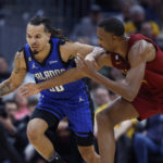 
              Orlando Magic guard Cole Anthony, left, controls the ball against Cleveland Cavaliers forward Evan Mobley, right, during the second half of an NBA basketball game, Friday, Dec. 2, 2022, in Cleveland. (AP Photo/Ron Schwane)
            