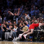 
              Ohio State guard Sean McNeil crashes into the scores table during the overtime of an NCAA college basketball game against North Carolina in the CBS Sports Classic, Saturday, Dec. 17, 2022, in New York. The Tar Heels won 89-84 in overtime. (AP Photo/Julia Nikhinson)
            