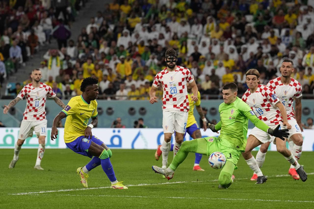 Brazil's Vinicius Junior, left, tries to score past Croatia's goalkeeper Dominik Livakovic who make...