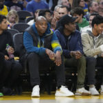 
              Comedians Dave Chappelle, middle left, and Chris Rock, middle right, sit courtside during the first half of an NBA basketball game between the Golden State Warriors and the Boston Celtics in San Francisco, Saturday, Dec. 10, 2022. (AP Photo/Godofredo A. Vásquez)
            
