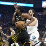 
              Golden State Warriors forward Kevon Looney, center left, drives to the basket against Memphis Grizzlies center Steven Adams, center right, during the first half of an NBA basketball game in San Francisco, Sunday, Dec. 25, 2022. (AP Photo/Godofredo A. Vásquez)
            