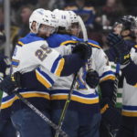 
              St. Louis Blues' Jordan Kyrou, from left to right, Robert Thomas, Justin Faulk and Vladimir Tarasenko, of Russia, celebrate Kyrou's third goal against the Vancouver Canucks during the third period of an NHL hockey game in Vancouver, British Columbia, on Monday, Dec. 19, 2022.  (Darryl Dyck/The Canadian Press via AP)
            