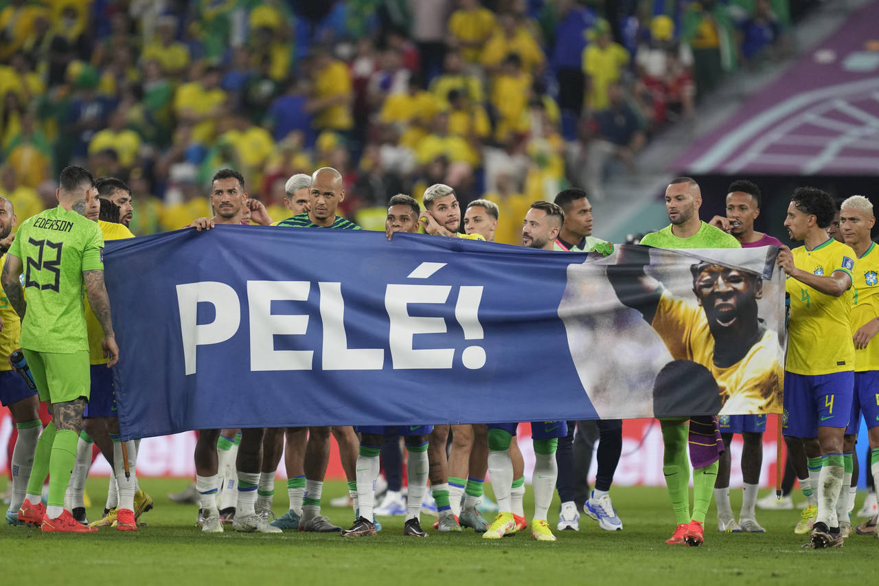 Brazilian players hold a banner in honour of the 82-year-old Brazilian soccer legend Pele who is in...