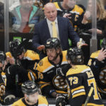 
              Boston Bruins head coach Jim Montgomery talks with his players during the first period of an NHL hockey game against the New York Islanders, Tuesday, Dec. 13, 2022, in Boston. (AP Photo/Charles Krupa)
            