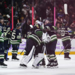 
              Vancouver Canucks' Riley Stillman, right, Ethan Bear, back, and goalie Spencer Martin celebrate after the Canucks defeated the Arizona Coyotes during overtime in an NHL hockey game Saturday, Dec. 3, 2022, in Vancouver, British Columbia. (Darryl Dyck/The Canadian Press via AP)
            