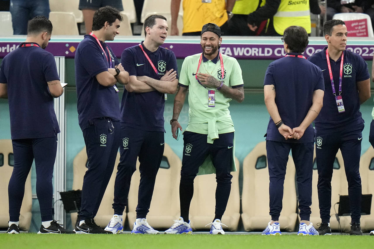 Brazil's Neymar, center, speaks with his team staff prior to the World Cup group G soccer match bet...