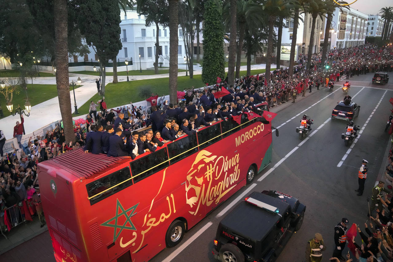 The players of Morocco national soccer team celebrate on a bus and wave during a homecoming parade ...