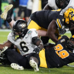 
              Wake Forest running back Justice Ellison (6) slips a tackle by Missouri defensive lineman Realus George Jr. (99) to score during the first half of the Gasparilla Bowl NCAA college football game Friday, Dec. 23, 2022, in Tampa, Fla. (AP Photo/Chris O'Meara)
            