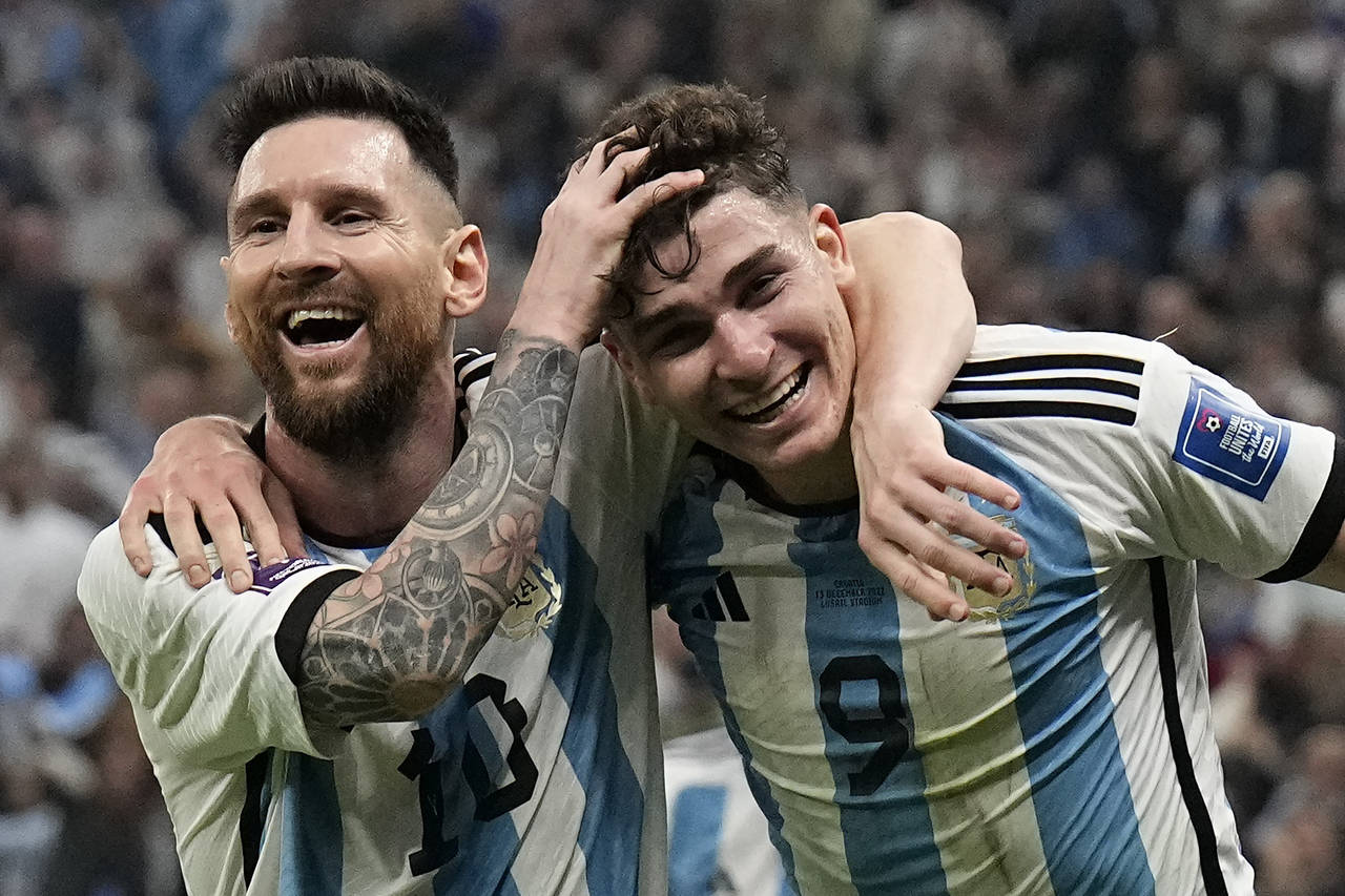 Argentina's Lionel Messi, left, and Argentina's Julian Alvarez celebrate after scoring during the W...