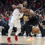 
              Atlanta Hawks guard Dejounte Murray, right, drives to the basket pass Brooklyn Nets guard Kyrie Irving during the first half of an NBA basketball game, Wednesday, Dec. 28, 2022, in Atlanta. (AP Photo/Hakim Wright Sr.)
            