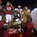 
              Arkansas players hoist the trophy after a three-overtime win over Kansas in the Liberty Bowl NCAA college football game Wednesday, Dec. 28, 2022, in Memphis, Tenn. Arkansas won 55-53. (AP Photo/Rogelio V. Solis)
            