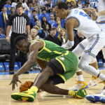 
              Oregon center N'Faly Dante, left, dives for the ball while UCLA guards Amari Bailey and Jaime Jaquez Jr. look on during an NCAA college basketball game Sunday, Dec. 4, 2022, in Los Angeles. (AP Photo/John McCoy)
            