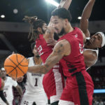 
              Nicholls State forward Marek Nelson (0) reaches for a blocked ball as Mississippi State guard Eric Reed Jr., right, tries to regain possession during the first half of an NCAA college basketball game, in Starkville, Miss., Saturday, Dec. 17, 2022. (AP Photo/Rogelio V. Solis)
            