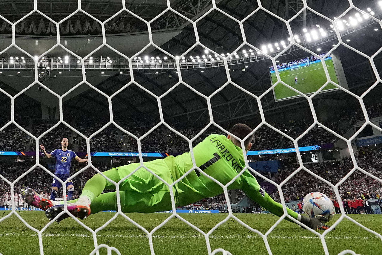Croatia's goalkeeper Dominik Livakovic saves from Japan's Maya Yoshida during a penalty shootout at...