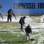 
              Crews remove tarps that covered the field overnight before an NFL football game between the Tennessee Titans and the Houston Texans, Saturday, Dec. 24, 2022, in Nashville, Tenn. Extreme cold weather has hit the region. (AP Photo/John Amis)
            