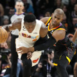 
              Phoenix Suns guard Chris Paul, right, fouls Miami Heat guard Victor Oladipo (4) during the first half of an NBA basketball game in Phoenix, Friday, Jan. 6, 2023. (AP Photo/Ross D. Franklin)
            