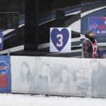 
              A Buffalo Bills fan walks past signs supporting Buffalo Bills safety Damar Hamlin prior to an NFL wild-card playoff football game between the Buffalo Bills and the Miami Dolphins, Sunday, Jan. 15, 2023, in Orchard Park, N.Y. (AP Photo/Joshua Bessex)
            
