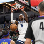 
              Minnesota Timberwolves forward Jaden McDaniels (3) dunks the ball as Denver Nuggets forward Bruce Brown, left, looks on during the first half of an NBA basketball game, Monday, Jan. 2, 2023, in Minneapolis. (AP Photo/Craig Lassig)
            