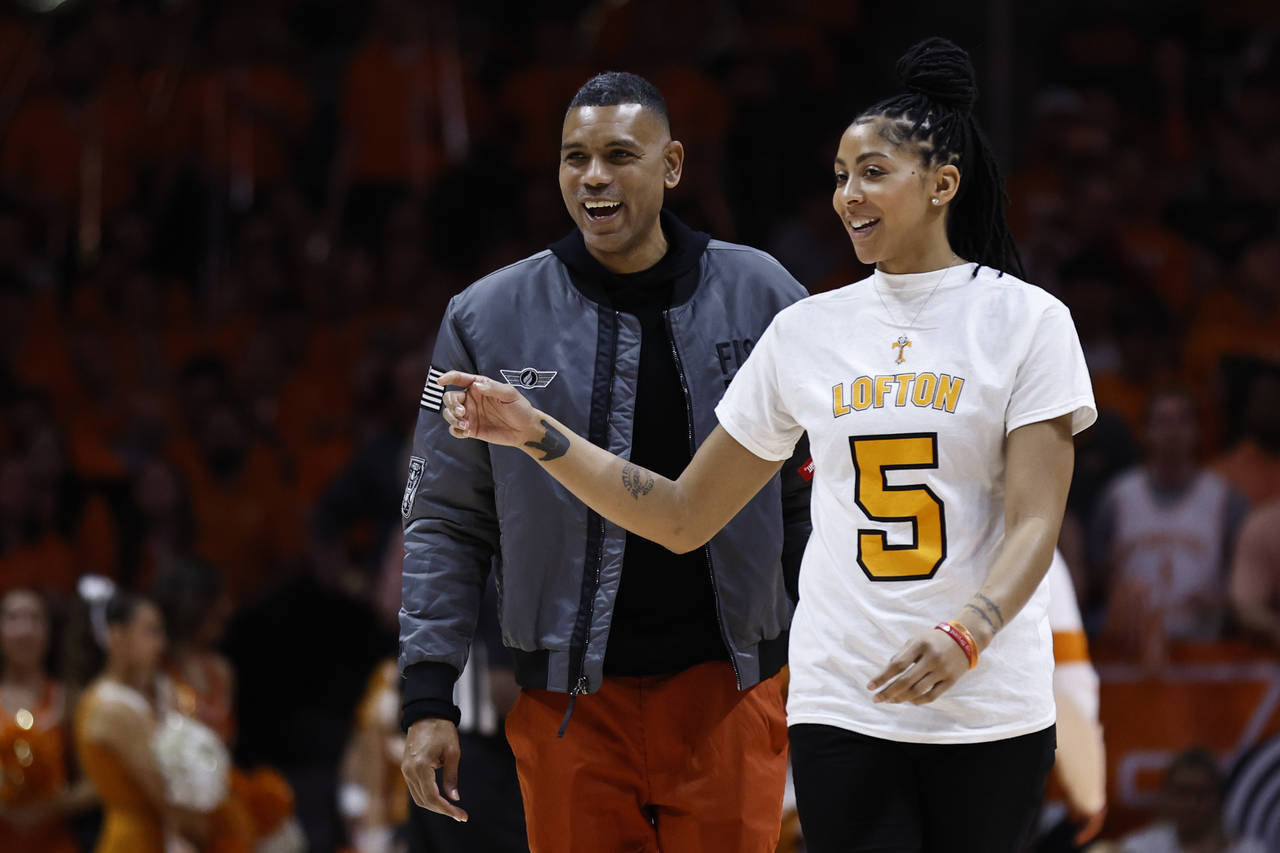 Former Tennessee basketball players Alan Houston and Candace Parker walk to the court as they were ...