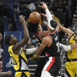 
              Indiana Pacers guards Bennedict Mathurin (00) and Tyrese Haliburton (0) go for a rebound over Portland Trail Blazers guard Shaedon Sharpe during the first quarter of an NBA basketball game, Friday, Jan. 6, 2023, in Indianapolis. (AP Photo/Marc Lebryk)
            