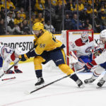 
              Nashville Predators defenseman Roman Josi (59) gets control of the puck as Montreal Canadiens center Kirby Dach (77) reaches in during the second period of an NHL hockey game Tuesday, Jan. 3, 2023, in Nashville, Tenn. (AP Photo/Mark Zaleski)
            