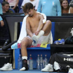 
              J.J. Wolf of the U.S. changes his socks during his fourth round match against compatriot Ben Shelton at the Australian Open tennis championship in Melbourne, Australia, Monday, Jan. 23, 2023. (AP Photo/Ng Han Guan)
            
