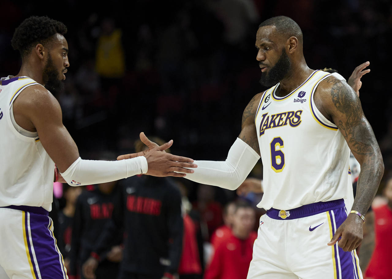 Los Angeles Lakers forward LeBron James, right, and forward Troy Brown Jr. celebrate after defeatin...