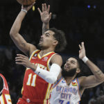 
              Atlanta Hawks guard Trae Young (11) goes up for a shot around Oklahoma City Thunder forward Kenrich Williams (34) in the first half of an NBA basketball game, Wednesday, Jan. 25, 2023, in Oklahoma City. (AP Photo/Kyle Phillips)
            