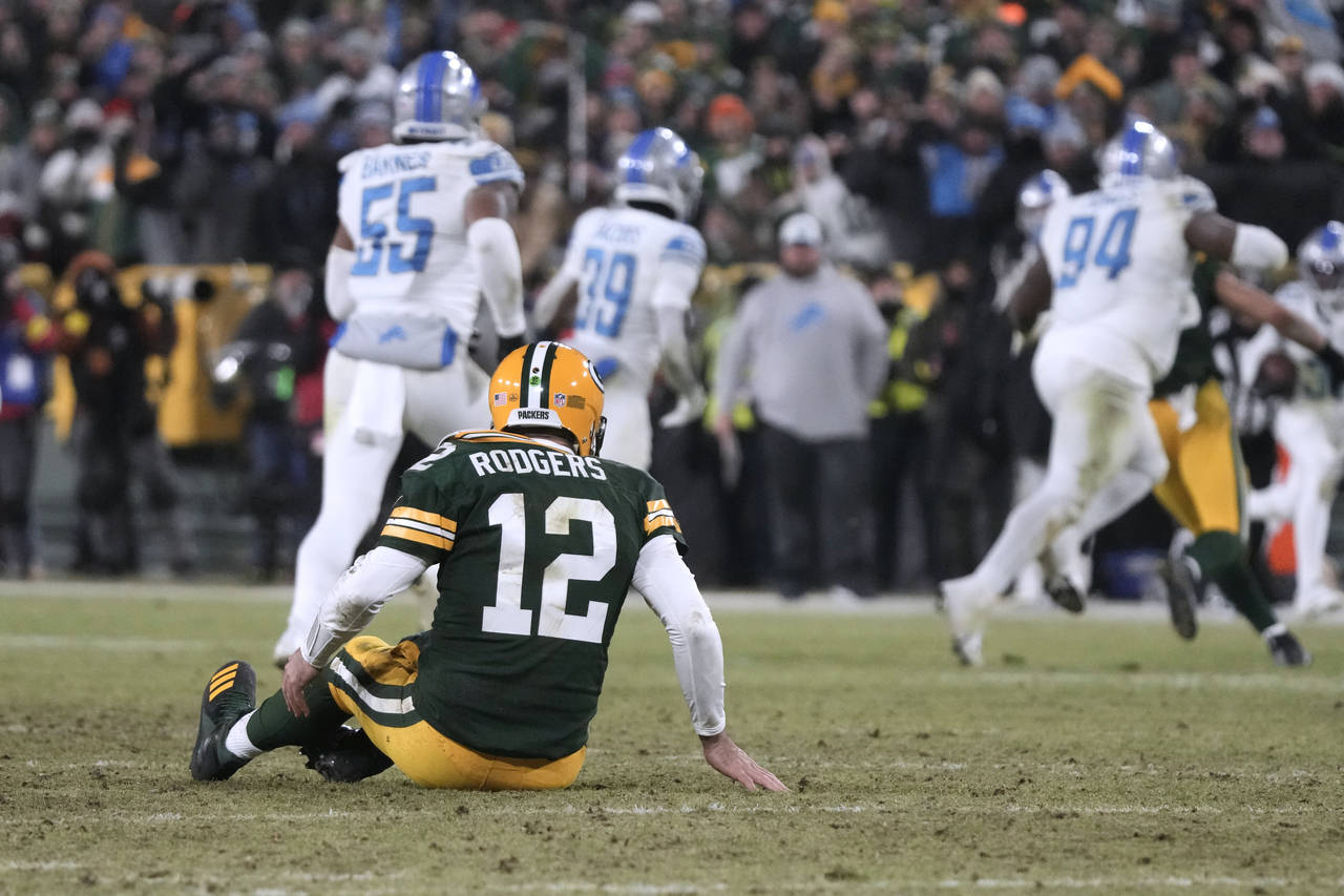 Green Bay Packers quarterback Aaron Rodgers sits on the turf after throwing an interception during ...