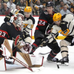 
              Pittsburgh Penguins' Bryan Rust (17) and Jake Guentzel (59) can't get to a rebound in front of Ottawa Senators goaltender Cam Talbot (33) with Jacob Bernard-Docker (24) defending during the second period of an NHL hockey game in Pittsburgh, Friday, Jan. 20, 2023. (AP Photo/Gene J. Puskar)
            
