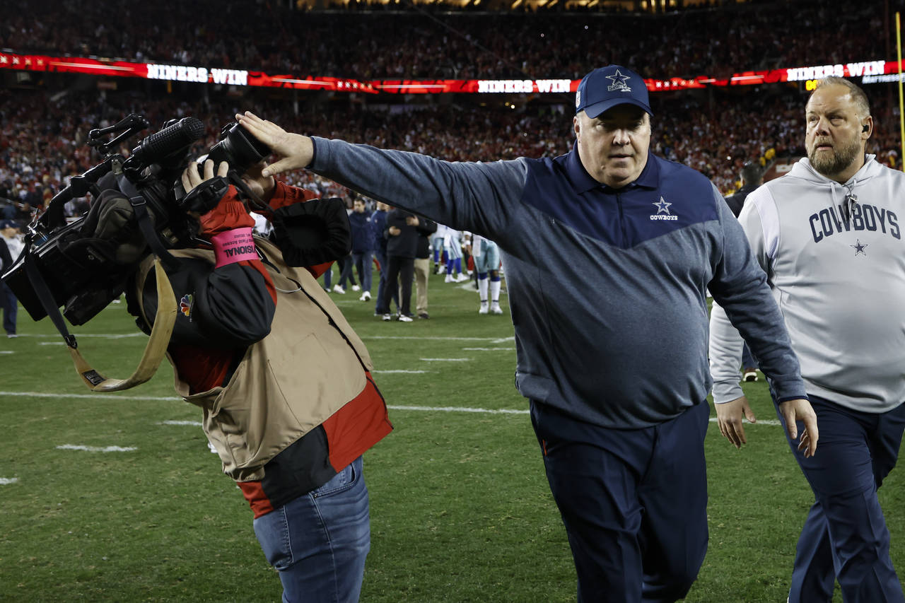 Dallas Cowboys head coach Mike McCarthy pushes a cameraman away while walking off the field after a...