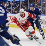 
              Detroit Red Wings center Dylan Larkin (71) and Toronto Maple Leafs defenseman Timothy Liljegren (37) chase the puck behind the Maple Leafs net during the third period of an NHL hockey game Saturday, Jan. 7, 2023, in Toronto. (Christopher Katsarov/The Canadian Press via AP)
            