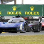 
              Earl Bamber, of New Zealand, center, in a Cadillac V-LMDh, leads Jack Aitken, of Great Britain, right, in a Cadillac V-LMDh and Filipe Albuquerque, of Portugal, left, in a Acura ARX-06 during the Rolex 24 hour auto race at Daytona International Speedway, Sunday, Jan. 29, 2023, in Daytona Beach, Fla. (AP Photo/John Raoux)
            