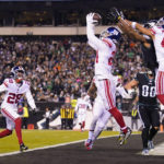 
              New York Giants safety Dane Belton, center, intercepts a pass from Philadelphia Eagles quarterback Jalen Hurts, not visible, intended for wide receiver DeVonta Smith, center right, during the second half of an NFL football game, Sunday, Jan. 8, 2023, in Philadelphia. (AP Photo/Matt Slocum)
            