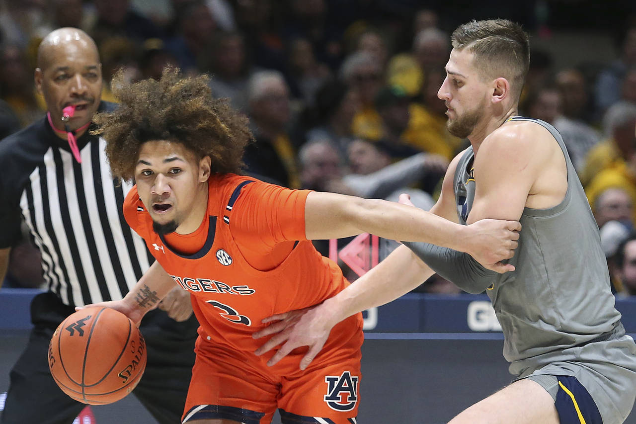 Auburn guard Tre Donaldson (3) is defended by West Virginia guard Erik Stevenson during the first h...