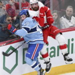 
              Montreal Canadiens' Rafael Harvey-Pinard (49) checks Detroit Red Wings' Filip Hronek into the boards during first-period NHL hockey game action in Montreal, Thursday, Jan. 26, 2023. (Graham Hughes/The Canadian Press via AP)
            