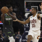 
              Minnesota Timberwolves guard Anthony Edwards (1) handles the ball against Cleveland Cavaliers forward Isaac Okoro (35) during the first half of an NBA basketball game Saturday, Jan. 14, 2023, in Minneapolis. (AP Photo/Stacy Bengs)
            