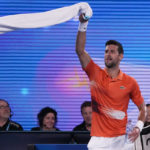 
              Serbia's Novak Djokovic swings his towel as he dances between games during an exhibition match against Australia's Nick Kyrgios on Rod Laver Arena ahead of the Australian Open tennis championship in Melbourne, Australia, Friday, Jan. 13, 2023. (AP Photo/Mark Baker)
            