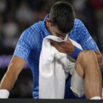 
              Novak Djokovic of Serbia reacts as he stretches his legs during his second round match against Enzo Couacaud of France at the Australian Open tennis championship in Melbourne, Australia, Thursday, Jan. 19, 2023. (AP Photo/Aaron Favila)
            
