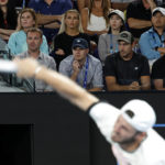 
              Tommy Paul of the U.S. serves to Novak Djokovic of Serbia as his team watch from the players box during their semifinal at the Australian Open tennis championship in Melbourne, Australia, Friday, Jan. 27, 2023. (AP Photo/Asanka Brendon Ratnayake)
            