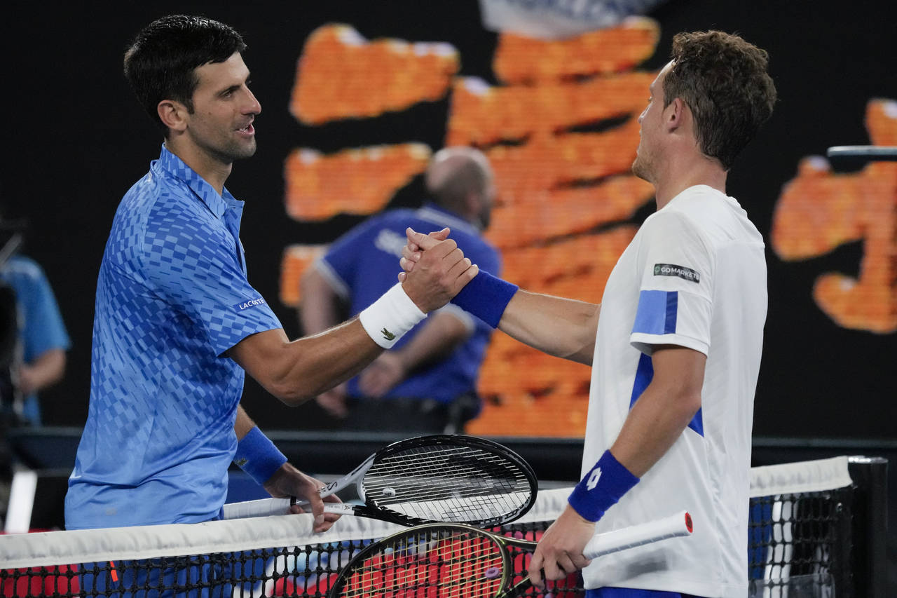 Novak Djokovic, left, of Serbia is congratulated by Roberto Carballes Baena of Spain following thei...