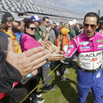 
              Helio Castroneves, right, greets fans before the start of the Rolex 24 hour auto race at Daytona International Speedway, Saturday, Jan. 28, 2023, in Daytona Beach, Fla. (AP Photo/John Raoux)
            
