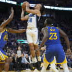 
              Orlando Magic guard Cole Anthony (50) goes up to shoot between Golden State Warriors forwards Andrew Wiggins, left, and Draymond Green (23) during the first half of an NBA basketball game in San Francisco, Saturday, Jan. 7, 2023. (AP Photo/Jeff Chiu)
            